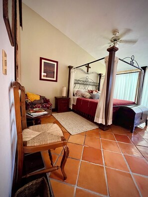 A bedroom with a four-poster bed, a wooden chair, a bedside table, and a ceiling fan. - Delightful 3-bedroom house with pool, AC near Marina & Beach in Puerto Vallarta (Puerto Vallarta)