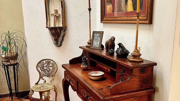 Ein traditioneller Holztisch mit Schubladen, einer Lampe und dekorativen Gegenständen.
