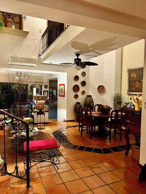 A spacious living area with a dining table, chairs, a sofa, and a staircase. - Delightful 3-bedroom house with pool, AC near Marina & Beach in Puerto Vallarta (Puerto Vallarta)