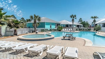 A swimming pool with lounge chairs and a hot tub area.