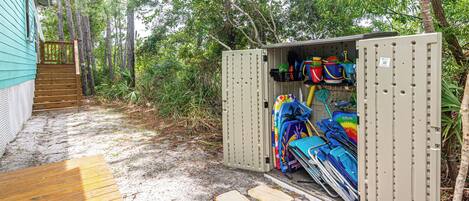 A storage unit with various items including a kayak, a paddleboard, and a canoe.