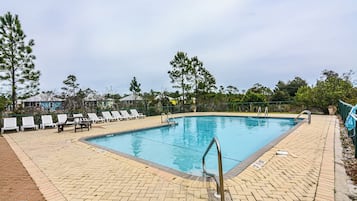 Una piscina con sillones de descanso y un puesto de socorristas.