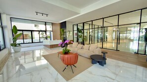 A spacious lobby with a large seating area, a reception desk, and large windows providing natural light. - Urban Oasis Ocean-View Studio with Balcony (Santo Domingo)