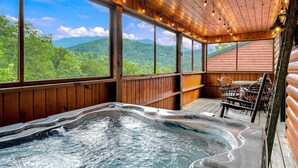 Ein Whirlpoolbereich mit Bergblick, Holzwänden und Lichterketten.