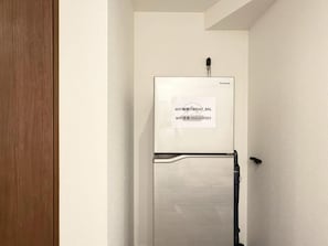 A white wall with a Panasonic refrigerator mounted on it. - NIKYO Taisho BLA Private Villa OSAKA (Osaka)