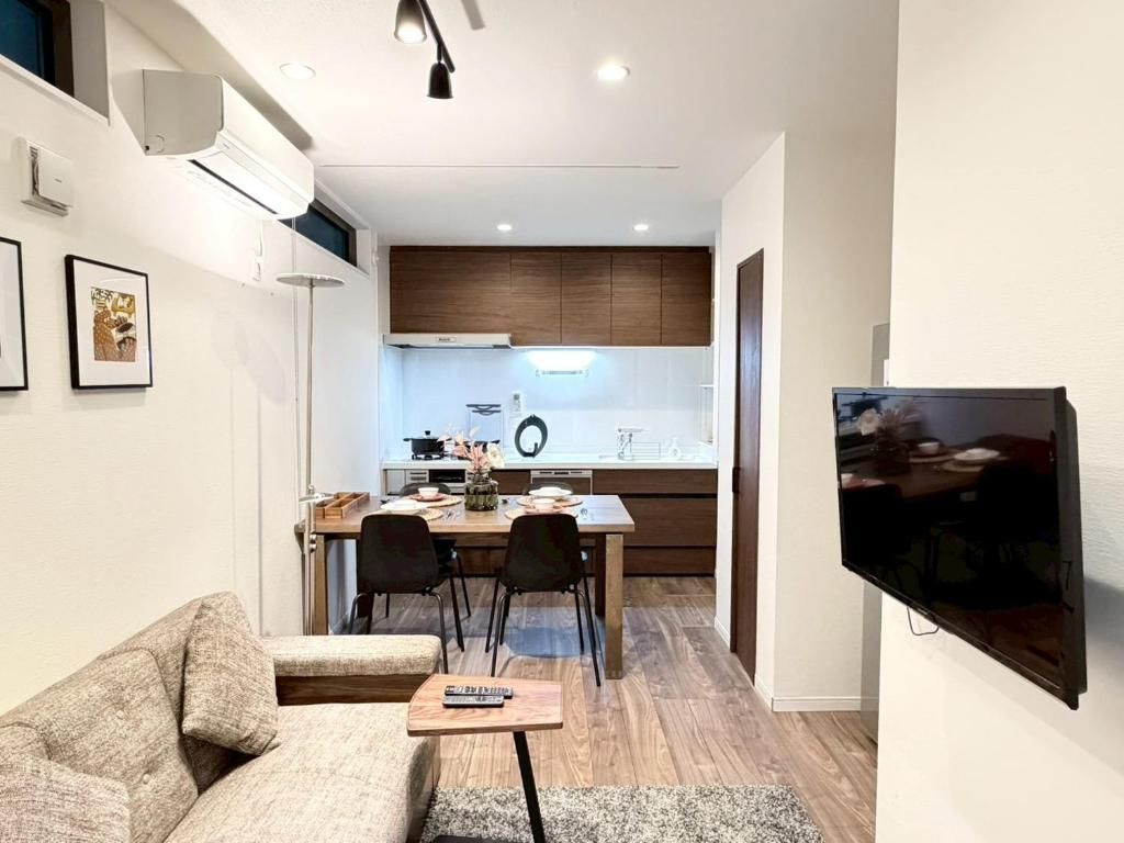A modern living room with a sofa, a coffee table, and a TV mounted on the wall.