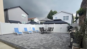 A patio with a table and chairs, a covered seating area, and a white fence. - Apartment in Newark,
sleeps 5+, spacious & near NY (Newark)