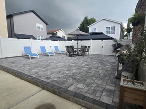 A patio with a table and chairs, a covered seating area, and a white fence. - Apartment in Newark,
sleeps 5+, spacious & near NY (Newark)