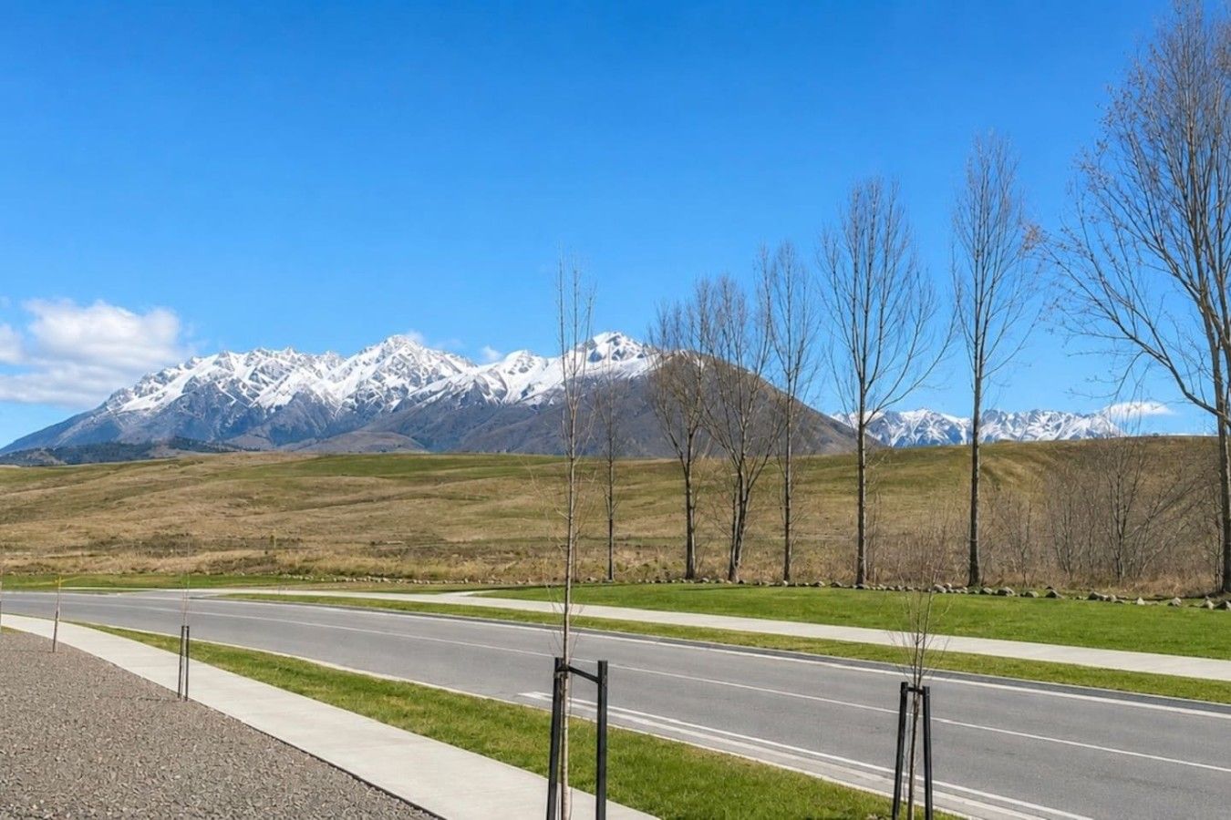 A road with a mountain range in the background.