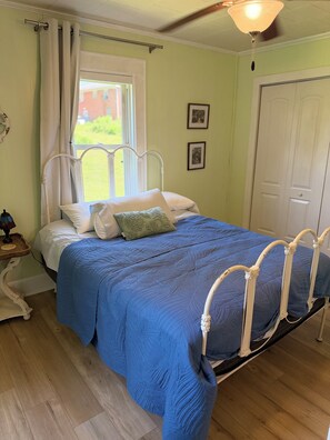 A bedroom with a bed, a window, a door, and a ceiling fan. - Fantastic 3-bedroom dog friendly retro farmhouse in charming Jonesville (Jonesville)