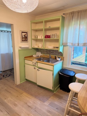 A compact kitchen with a sink, cabinets, and a window. - Fantastic 3-bedroom dog friendly retro farmhouse in charming Jonesville (Jonesville)