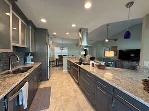 A modern kitchen with granite countertops, stainless steel appliances, and a large island. - Serene 2 Bedroom 2 Bath Villa with Lakeview in Myrtle Trace (Venice)