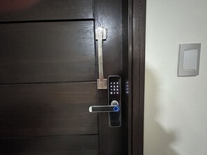 A door with a keypad lock and a lever handle. - Cala Cala Apartment (Cochabamba)