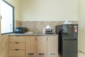 A compact kitchen with a microwave, sink, and a refrigerator. - Ambience Residence by Stayrene (Melaka)