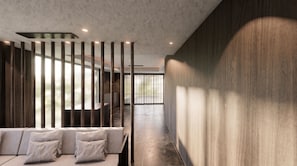 A modern interior with a seating area, a high ceiling, and a view through a partition.