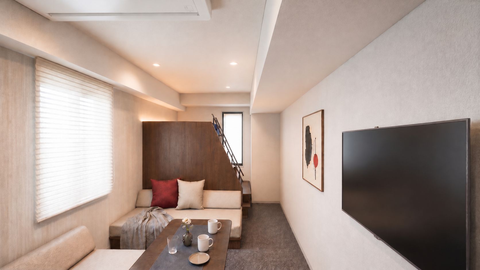 A modern living room with a sofa, a coffee table, and a flat-screen TV.