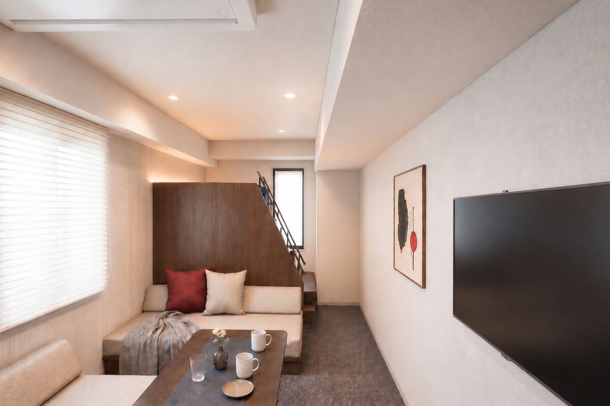 A modern living room with a sofa, a coffee table, and a flat-screen TV.