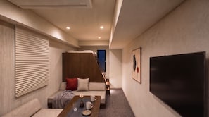A modern living room with a sofa, coffee table, and artwork on the wall.