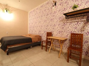 A bedroom with a bed, a desk, and two chairs. - Casa Corazon Centro (Oaxaca de Juárez)