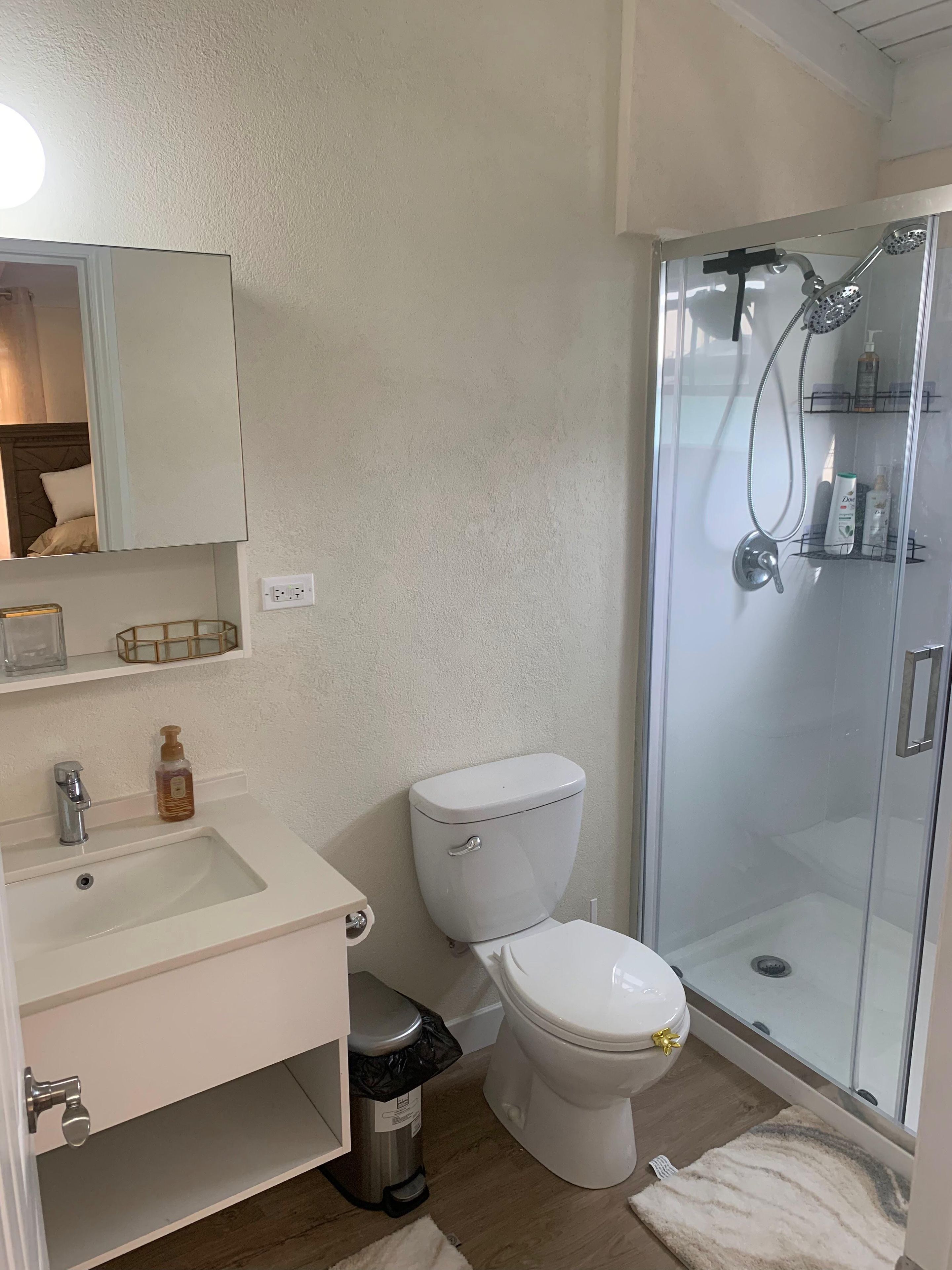 A bathroom with a toilet, sink, and glass-enclosed shower.