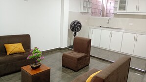 A modern living room with a sofa, armchair, and a small table with a plant. - An Airbnb-style vacation rental, perfect if you're visiting Podocarpus Park. (Zamora)