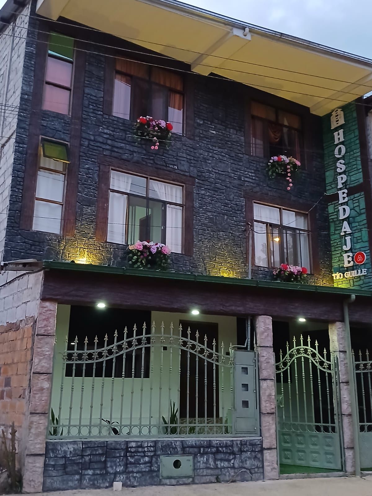 Un bâtiment à deux étages avec une enseigne indiquant « HOSPEDAL » et « TO GUILLE ».