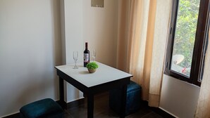 A small room with a white table, two chairs, a bottle of wine, and a potted plant. - An Airbnb-style vacation rental, perfect if you're visiting Podocarpus Park. (Zamora)