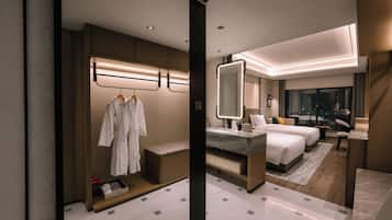 Een moderne hotelkamer met een groot bed, een zithoek, een badkamer en een kledingkast met badjassen.