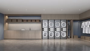 Un moderno cuarto de lavandería con lavadoras y secadoras múltiples, un lavabo y un tendedero.