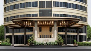 Un hotel moderno con fachada circular, amplios ventanales y una entrada central con columnas.