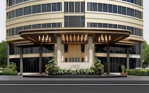 A modern hotel with a circular facade, large windows, and a central entrance with columns. - Yiwu Ocean Hotel  (yiwu)