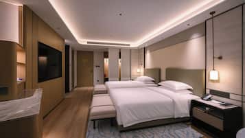 A modern hotel room with a large bed, bedside tables, a desk, and a television.