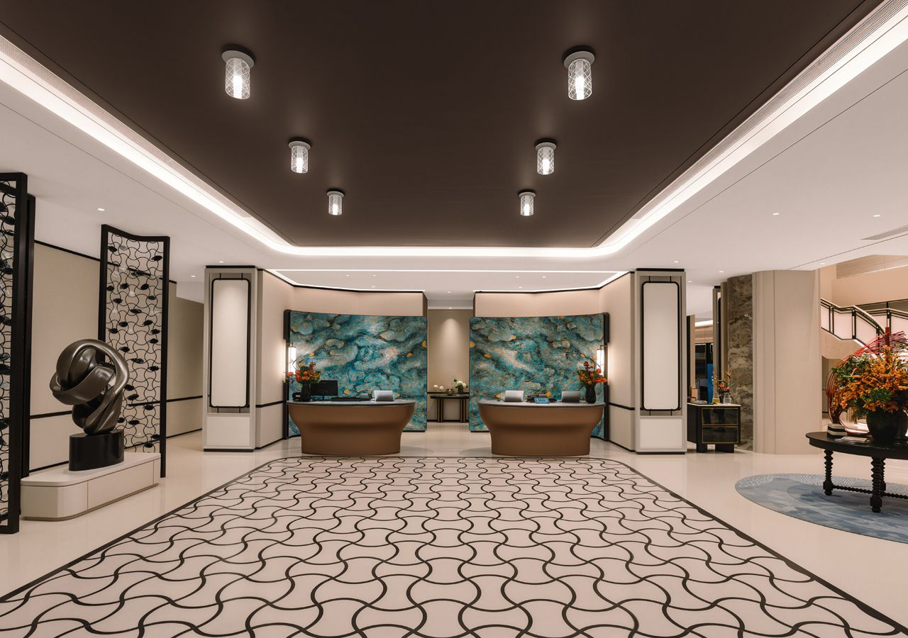 A reception area with a patterned floor, two reception desks, and decorative wall art.