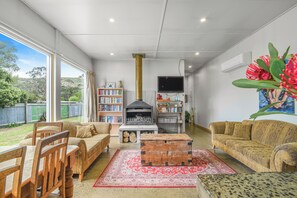 A spacious living room with a fireplace, a television, and a bookshelf.