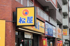 Uma fileira de edifícios comerciais com diversos anúncios e fachadas de lojas.