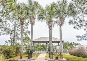 A gazebo with a metal roof, surrounded by tall palm trees and a pathway leading to it. - 5003 Rookery 3 The Sea Pearl (Gulf Shores)