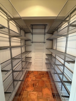 A walk-in closet with metal shelving units and a tiled floor. - Lakefront Escape with Kayaks & Views (West Milford)