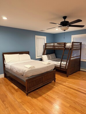 A bedroom with two bunk beds, wooden flooring, and a ceiling fan. - Lakefront Escape with Kayaks & Views (West Milford)