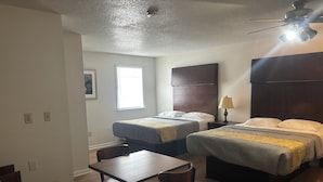 A hotel room with two beds, a table, and a chair. - Hobson Stay & Residences (Grand Junction)