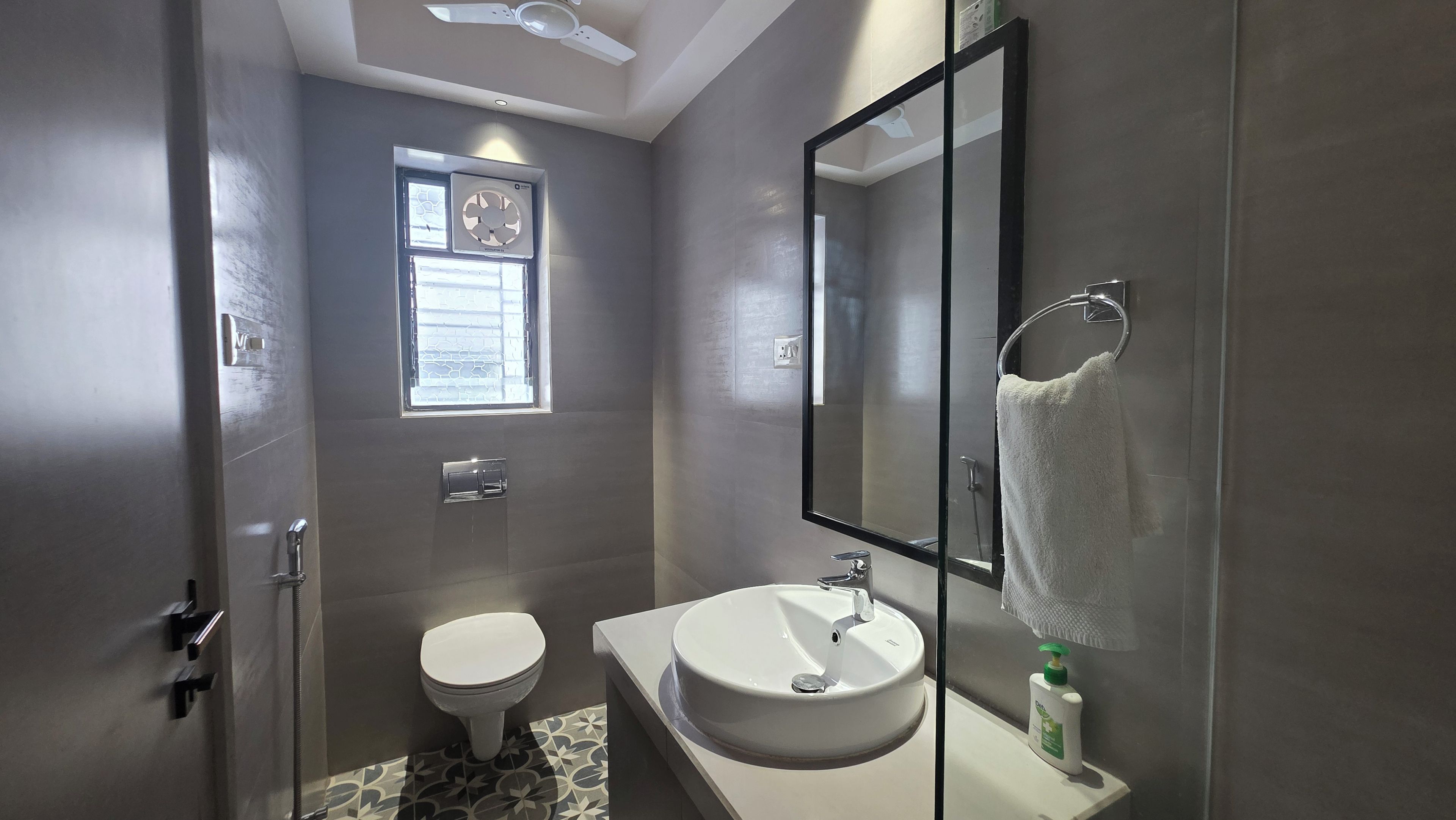 A bathroom with a toilet, sink, and a mirror.