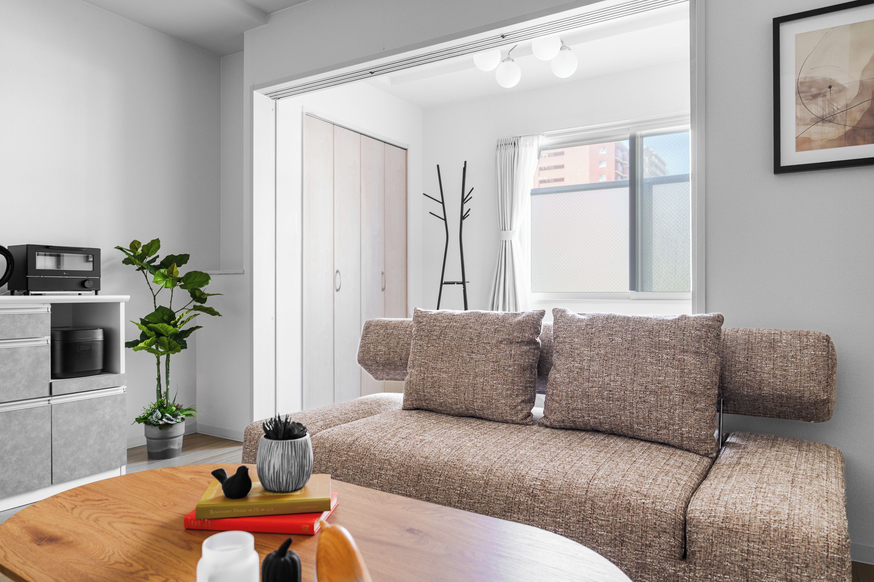 A modern living room with a sofa, a coffee table, and a bookshelf.