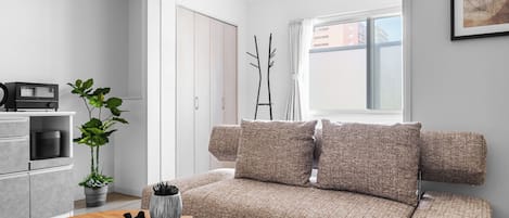 Una sala de estar moderna con un sofá, una mesita de centro y una estantería.