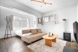 A modern living room with a sofa, a coffee table, a fireplace, and a television. - SONIA 103 (Sapporo)