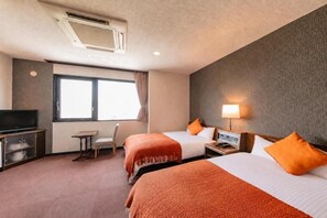Habitación de hotel con dos camas, televisión, escritorio y ventana.