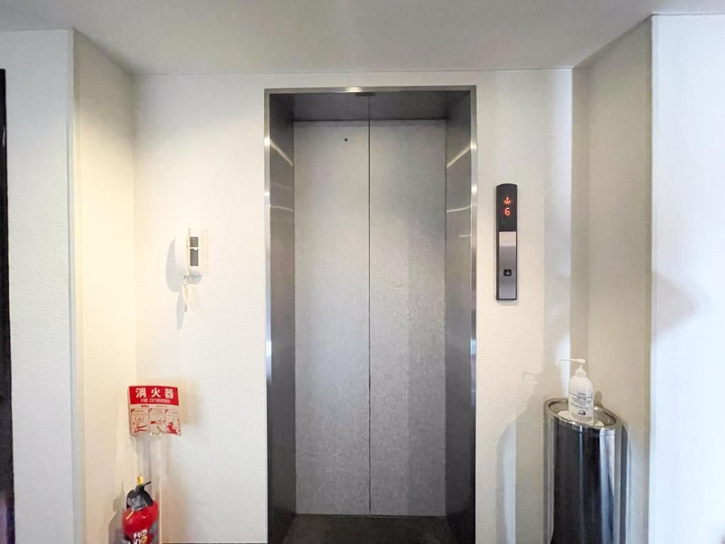 An elevator with a fire alarm and a hand sanitizer dispenser.