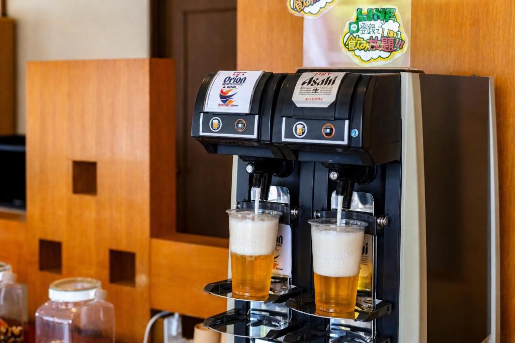 Una máquina de café con dos dispensadores sirviendo cerveza en vasos.