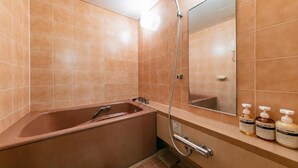 Kylpyhuoneessa on kylpyamme, suihku ja peili. Pesualtaalla on hygieniatuotteita.