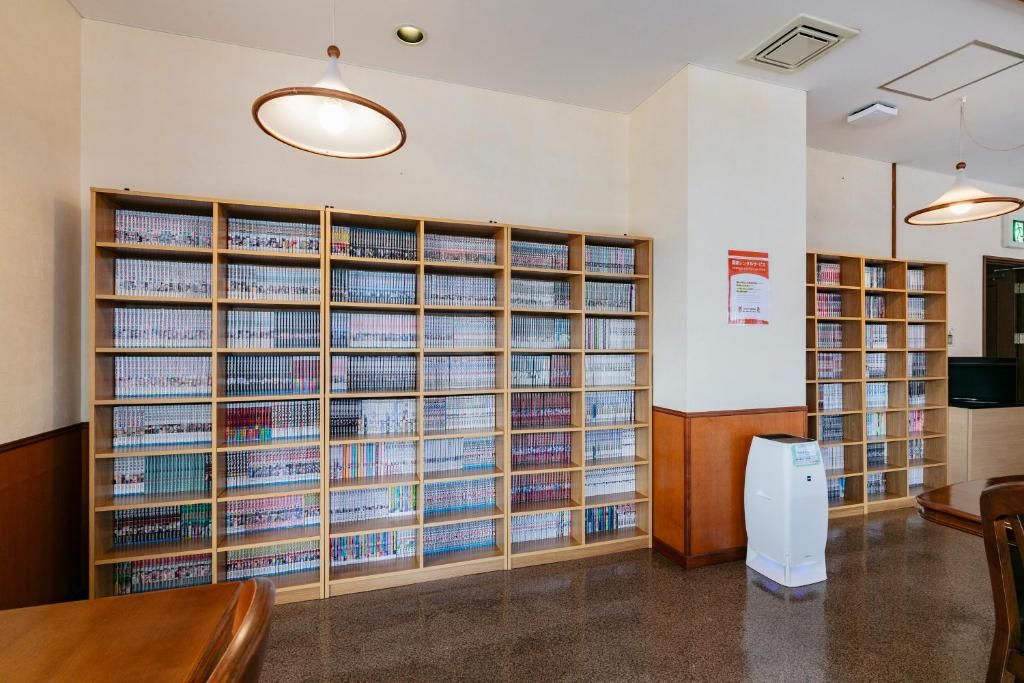 Interior de biblioteca con varias estanterías, una mesa de madera y un purificador de aire blanco.