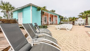 A beachside lounge area with sun loungers and a small building with a blue exterior. - 5002 Rookery 1/4 mile beach 2 pools (Gulf Shores)