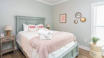 Un dormitorio con cama, mesitas de noche, un espejo en la pared y una ventana con persianas.